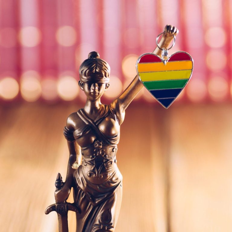 Statue of Temide - symbol of law and justice holding heart with lgbt colours. Lgbt rights and law
